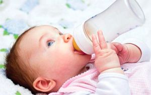 Малыш пьет молочную смесь из бутылочки