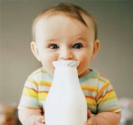 Годовалый ребенок и большая бутылка молока