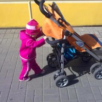 Ребёнок в розовом сам толкает коляску