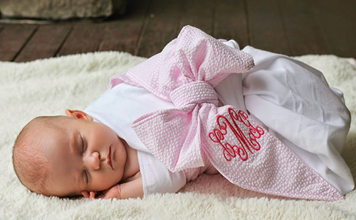 Новорожденная девочка в розовой пеленке