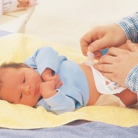 Новорожденному папины руки застёгивают подгузник