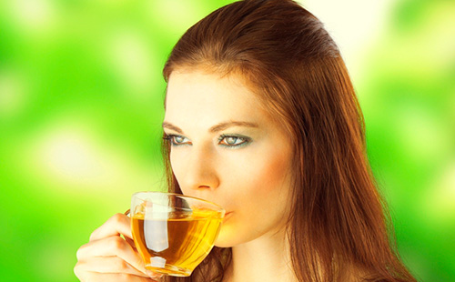 Молодая женщина пьет чай