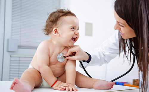 Добрый доктор обследует младенца