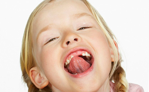Девочка с косичками показывает язык