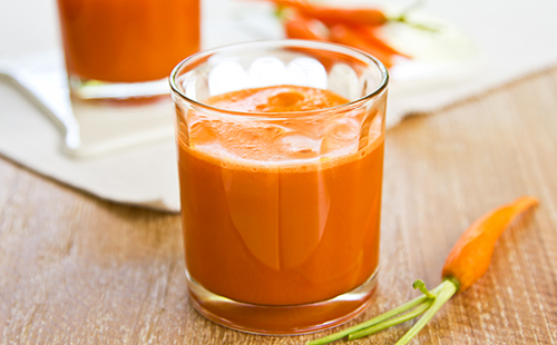 Оранжевый морковный сок в стеклянном стакане
