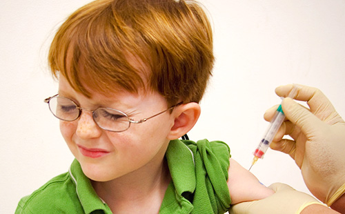 Мальчику в очках делают прививку