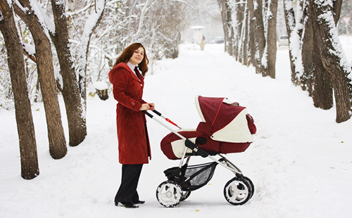 Мама гуляет с ребенком в коляске зимой