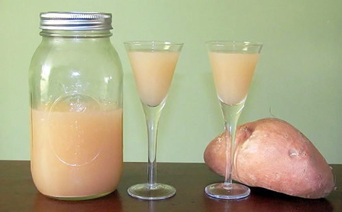 Разрезанная пополам картофелина и сок в высоких бокалах