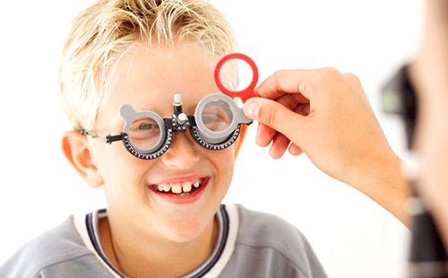 Улыбающийся мальчик на обследовании у глазного врача