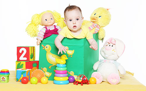 Малыш сидит в коробке с игрушками