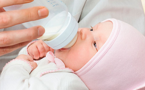 Новорожденный пьет кисломолочную смесь