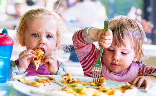 Двое малышей уплетают пиццу вместе