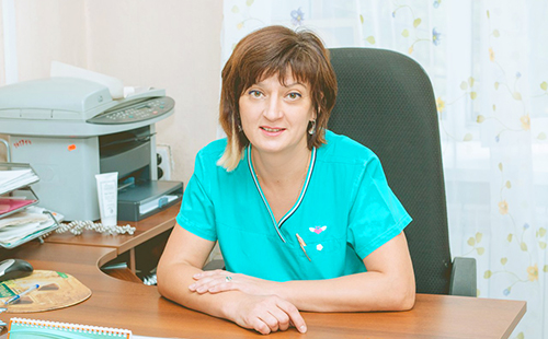 Женщина-врач сидит за столом