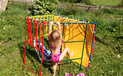 Девчушка в саду с энтузиазмом строит дом