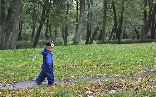 Ребёнок гуляет по дорожкам старого парка
