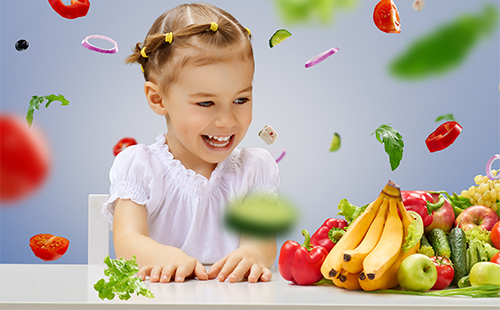Красивая маленькая девочка и фрукты на столе
