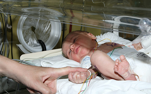 Новорожденный малыш в кювезе