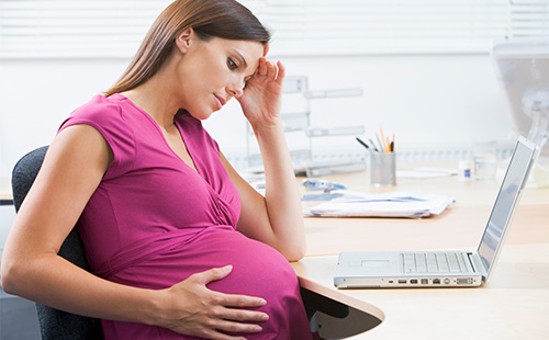 Беременная женщина держится за живот